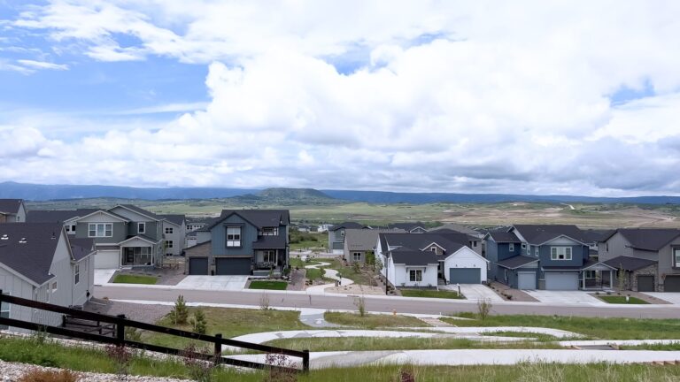 Panoramic view of new homes in a Colorado suburb with mountains in the distance