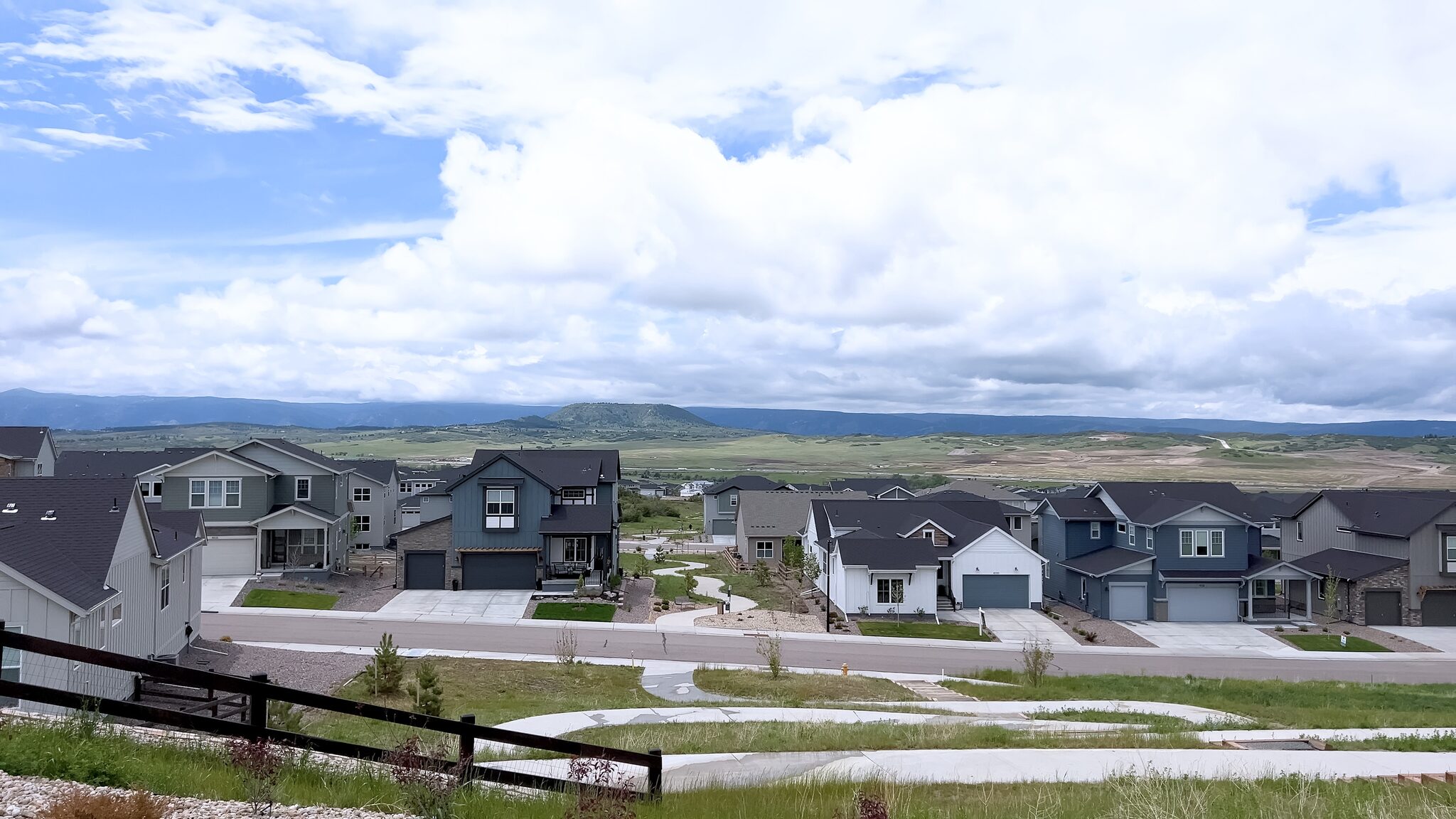 Panoramic view of new homes in a Colorado suburb with mountains in the distance